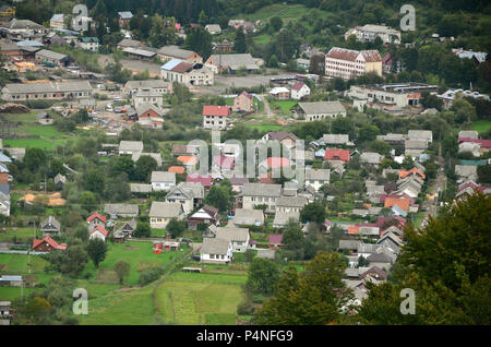 Eine wunderschöne Aussicht auf das Dorf Mezhgorye, Karpaten Region. Eine Menge von Wohngebäuden durch hohe Wald Berge und lange Fluss umgeben Stockfoto
