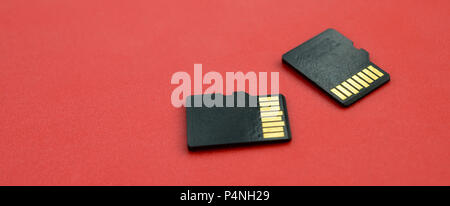 Zwei kleine Micro-SD-Karten liegen auf einem roten Hintergrund. Eine kleine und kompakte Daten und Informationen speichern. Stockfoto
