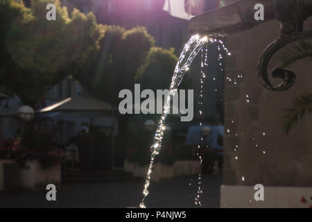 Messing antik Brunnen mit schimmernden Wasser im Wasserbehälter an einem sonnigen Tag Stockfoto