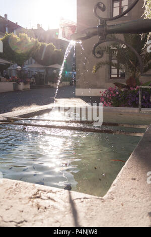 Messing antik Brunnen mit schimmernden Wasser im Wasserbehälter an einem sonnigen Tag Stockfoto
