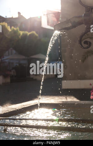 Messing antik Brunnen mit schimmernden Wasser im Wasserbehälter an einem sonnigen Tag Stockfoto