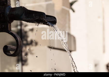 Messing antik Brunnen mit schimmernden Wasser im Wasserbehälter an einem sonnigen Tag Stockfoto