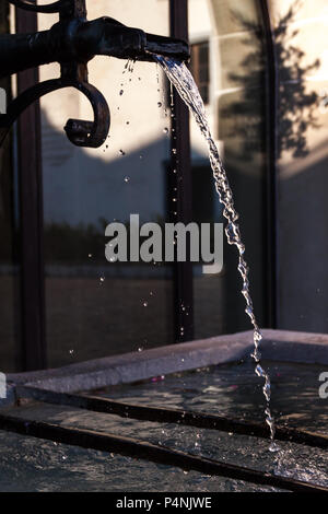 Messing antik Brunnen mit schimmernden Wasser im Wasserbehälter an einem sonnigen Tag Stockfoto