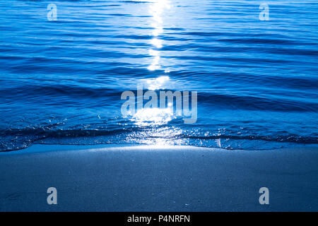 Das kristallklare Wasser am Strand im Sommer bei Nacht mit Mond Reflexion Stockfoto