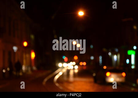 Verschwommen Nacht Szene der Verkehr auf der Fahrbahn. Defokussierten Bild des Autos Reisen mit leuchtenden Scheinwerfern. Bokeh Kunst Stockfoto