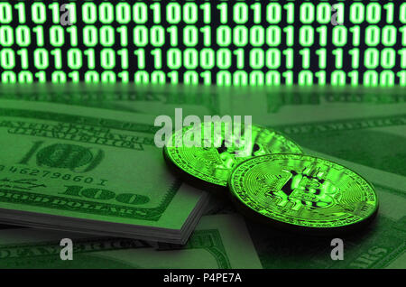 Zwei bitcoins liegt auf einem Stapel von dollarnoten auf dem Hintergrund eines Monitors mit der Darstellung eines binären Code der helle grüne Nullen und 1 Einheiten auf einem Schwarz Zurück Stockfoto