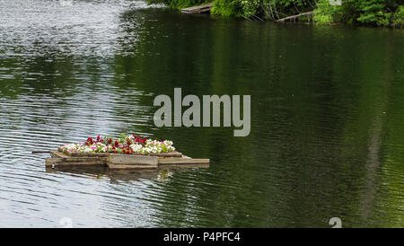 See im Sommer mit einem schwimmenden Blumenkasten mit Blumen blühen Stockfoto