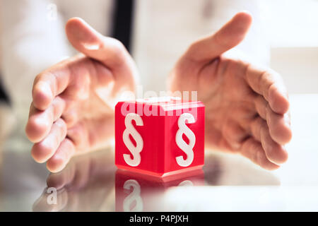 Nahaufnahme der schützende Hand rot Cubic einer Person Block mit Absatz Symbol Stockfoto