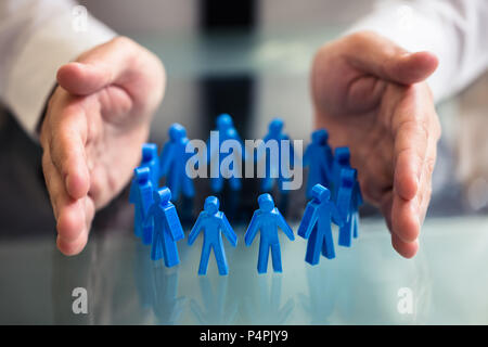 Nahaufnahme der Kaufmann schützende Hand blau menschliche Figuren bilden Kreis Stockfoto