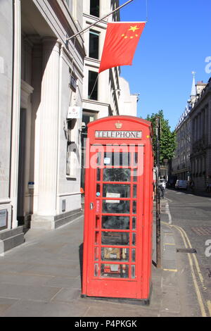 East meets West: Flagge von China Wellen über archetypische Britische rote Telefonzelle im Finanzviertel von London, England, UK, PETER GRANT Stockfoto