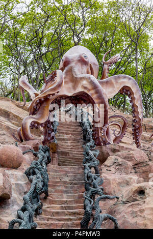 Russland, Wladiwostok, 26.05.2018. Skulptur von großen Kraken auf einem Felsen in einem Vergnügungspark. Elegante Treppe im nautischen Stil geht unter. Platziert Stockfoto