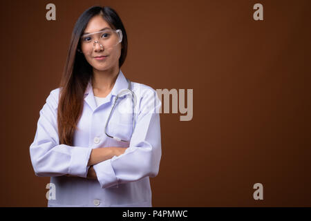 Junge schöne asiatische Frau Doktor tragen Schutzbrille ag Stockfoto