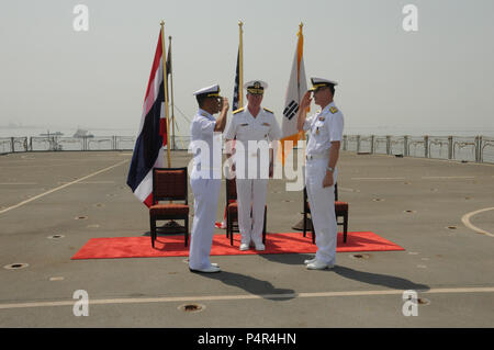 MINA SALMAN PIER, Bahrain (18. Juni 2012) Republik Korea Marine hinten Adm. Anho Chung, entlastet, Royal Thai Navy hinten Adm. Tanin Likitawong, Commander, kombinierte Task Force (CTF) 151 während Vice Adm. John. Miller, Commander, U.S. Naval Forces Central Command/Fünften Flotte/kombiniert maritimen Kräfte, Zentrum, beobachtet, während der Änderung des Befehls Zeremonie an Bord der Royal Fleet Auxiliary (RFA) Fort Victoria (A 387). CTF151 ist eine multi-nationale, Mission-basierten Task Force unter CMF, Zähler zu leiten - Piraterie Operationen im südlichen Roten Meer, Golf von Aden, Somalia Becken, Arabisches Meer, und den Indischen Ozean. Stockfoto