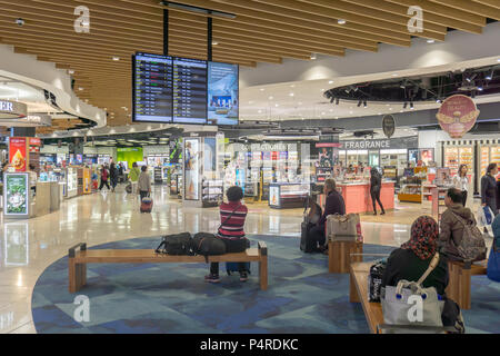 AUCKLAND, Neuseeland - Mai 8, 2018; Leute sitzen warten auf Flüge in der Nähe von Flugzeiten in Duty Free Shopping Bereich. Stockfoto