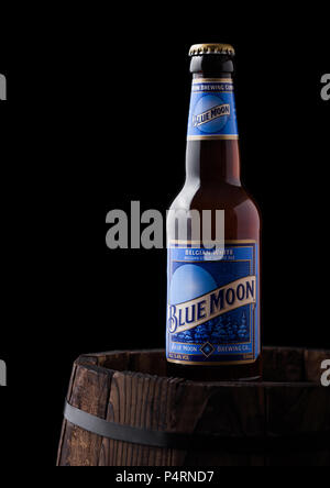 LONDON, UK - Juni 06, 2018: Flasche Blue Moon belgischen Weißbier, durch MillerCoors auf alten Holzfass auf schwarzem Hintergrund gebraut. Stockfoto