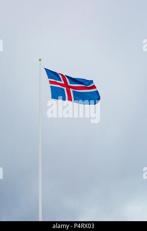 Eine zivile Flagge und Fähnrich Island gegen einen bewölkten Himmel. Die Nationalflagge der Isländer ist blau wie der Himmel mit einem Schnee-weißen Kreuz und eine feurig-r Stockfoto