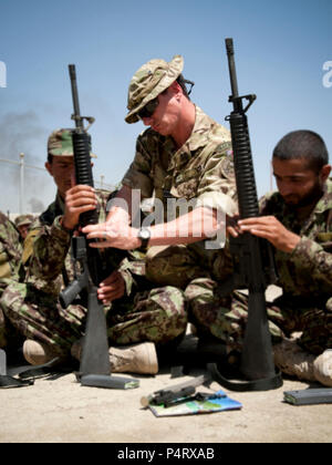 KABUL - Britische Flt. Lt Jim Smith, der britischen Führung Training Team, NATO Training Mission-Afghanistan, lehrt der afghanischen nationalen Armee Offizier kadetten M-16 Montage als Teil des grundlegenden Bereich Handwerk Kurs an der afghanischen nationalen Armee Officer Candidate School, Kabul militärische Ausbildung Mitte Mai 1. Officer Kadetten lernen, Unterstände, Durchführung von Feuern und Nacht Manöver als Teil des grundlegenden Bereich Handwerk Kurs zu bilden. Die kadetten sind in ihrer vierten Woche der 20 Woche Officer Candidate School. Stockfoto