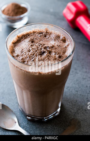 Protein Shake Schokolade Smoothie mit Whey Protein Pulver und roten Hanteln. Sports Drink Stockfoto