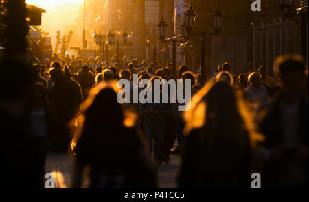 Silhouetten, die Menschenmenge auf der Straße am Sommerabend, schönes Licht bei Sonnenuntergang Stockfoto