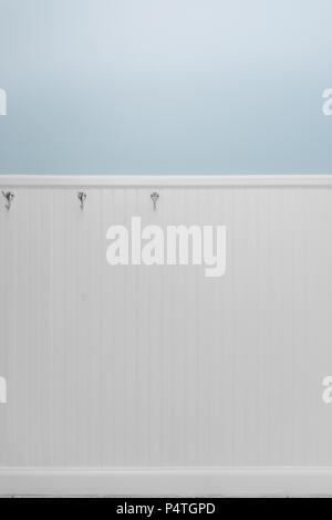 Leere Silber Haken auf weiße Perle Board oder holzvertäfelung mit hellblauen Wandfarbe Stockfoto