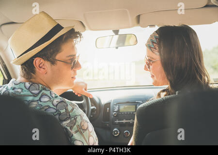 Schöne junge Paar in Liebe im Auto sitzen. Auf der Straße fahren. Stockfoto