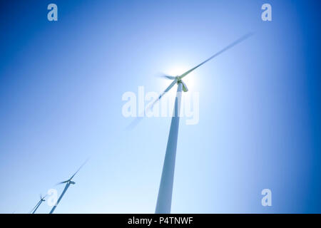 Eine Serie von drei Windkraftanlagen in einer Windmühle Park gegen ein strahlend blauer Himmel. Stockfoto