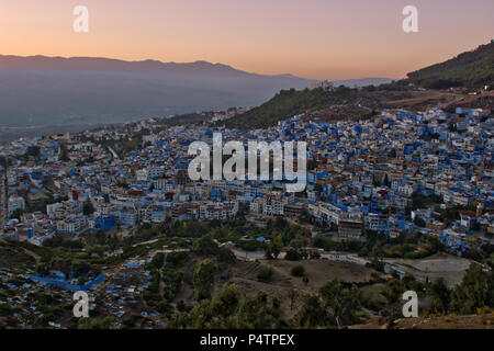 Ein Blick auf die marokkanische Stadt Chefchaouen bei Sonnenuntergang. Die Stadt ist berühmt für ihre blauen Gebäude. Stockfoto