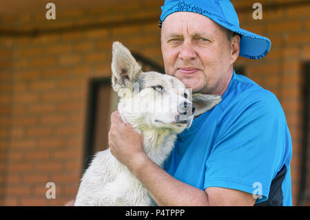 Schöne Outdoor Portrait von zwei glückliche Freunde - reifer Mann und seine reizende junge Hund Stockfoto
