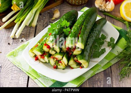 Traditionelle koreanische Essen Kimchi (Gurke). Marinierten Gurken mit Gemüse (Paprika, Knoblauch, Zwiebel, grünen, Tomatenmark) auf das KITCH Stockfoto