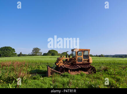 Eine alte und Caterpillar Bulldozer in einem Bauernhof Feld in der Nähe von Woking Dorf in Angus, Schottland geparkt. Stockfoto