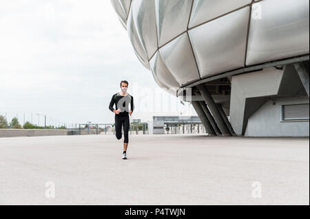 Mann bei Stadion läuft Stockfoto