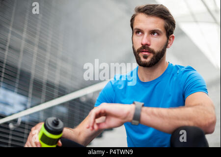 Mann sitzt auf der Treppe mit einer Unterbrechung von laufenden Stockfoto