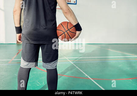 Mann mit Basketball, Innen Stockfoto