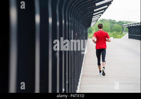 Ansicht der Rückseite des Mann laufen auf einer Brücke Stockfoto