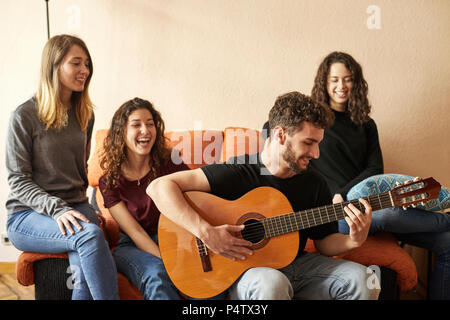 Gerne Freunde hören Mann spielt Gitarre auf der Couch Stockfoto