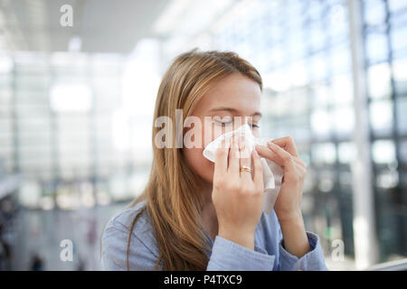 Junge Frau bläst Nase Stockfoto