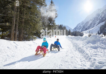 Paar Rodeln im verschneiten Landschaft Stockfoto