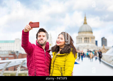 UK, London, Portrait von lächelnden jungen Paar unter selfie mit Handy vor der St Pauls Cathedral Stockfoto