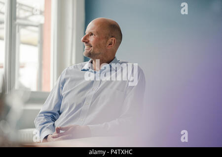 Lächelnd reife Geschäftsmann Blick aus Fenster Stockfoto