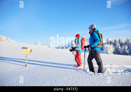 Österreich, Tirol, paar Schneeschuhwandern, vor Schild Stockfoto