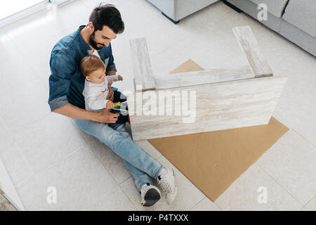 Vater und Tochter Montage eines hölzernen Tisch zu Hause Stockfoto