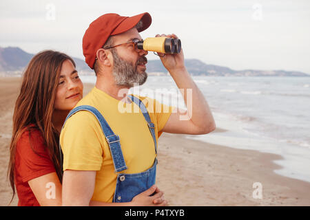 Paar mit einem Fernglas am Strand Stockfoto