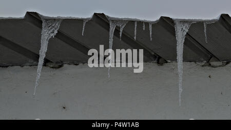 Gefrorenen Eiskristallen hängen vom Dach Stockfoto