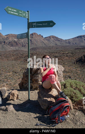Weibliche Touristen genießt die Aussicht auf Los Roques de Garcia in Las Canadas National Park, Teide, UNESCO Weltkulturerbe, Teneriffa, Kanarische Inseln Stockfoto