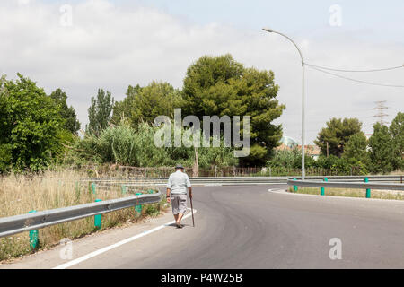 Valencia, Spanien, Mann mit Stock auf Landstraße am Stadtrand Stockfoto