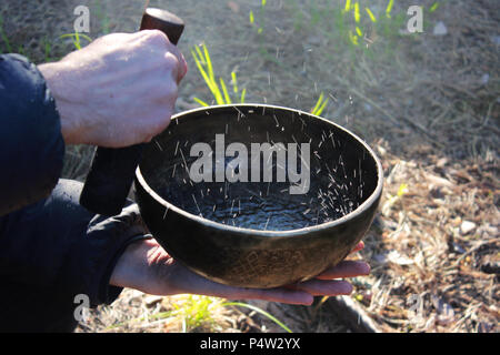 Klangschale mit Tanz wie kochendes Wasser im Sonnenlicht in der Natur als Folge von Spielen auf. Stockfoto