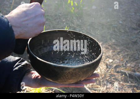 Klangschale mit Tanz wie kochendes Wasser im Sonnenlicht in der Natur als Folge von Spielen auf. Stockfoto