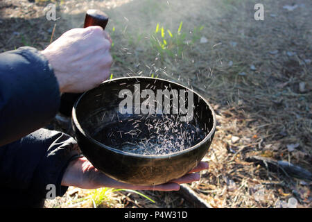 Klangschale mit Tanz wie kochendes Wasser im Sonnenlicht in der Natur als Folge von Spielen auf. Stockfoto