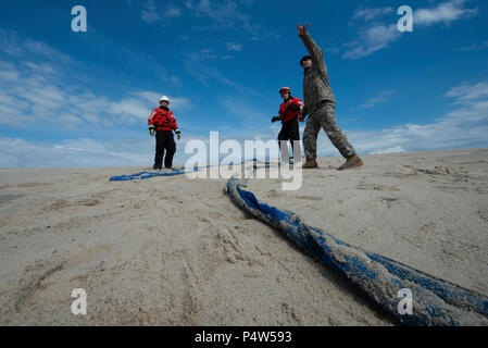 Sgt. 1. Klasse Chris Richards der Connecticut National Guard weist auf die beabsichtigten Flug weg einer CH-47 Chinook Hubschrauber der U.S. Coast Guard Chief Warrant Officer Benjamin Jewell, und Petty Officer 3rd Class Andrew Hayden der Coast Guard Cutter Eiche Dienstag, 9. Mai 2017, in der Nähe von Chatham, Massachusetts. Die Chinook hob ein 12.000-Pound Strände Boje und brachte es Offshore, in dem Sie durch die Küstenwache aufgegriffen wurde. Stockfoto