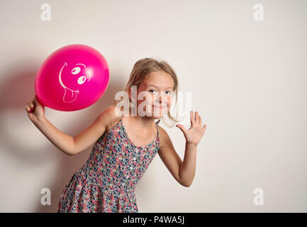 Fröhliches Kind mit einem roten Ballon Stockfoto